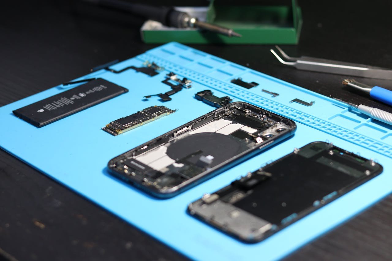 Services Disassembled smartphone with tools on a workbench, emphasizing repair and technology.